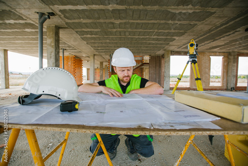 Surveyor engineer working at construction site with measuring eq photo