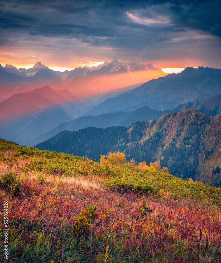 Сrack in the clouds at sunset. Unbelievable autumn view of mountain valley with Ushba peak. Colorful evening scene of Caucasus, Upper Svaneti, Georgia. Beauty of nature concept background..