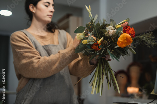 Florist making amazing decorative bouquet with dry flowers in workplace photo