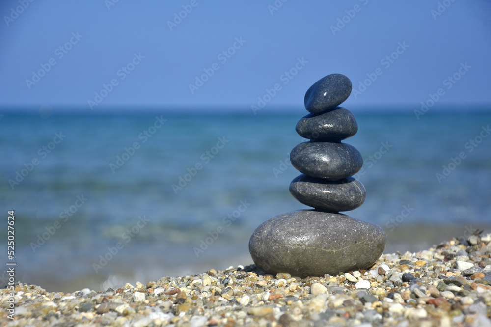 Balanced stone pyramid on sand on beach. Zen rock, concept of balance and harmony Balanced stone pyramid on sand on beach. Zen rock, concept of balance and harmony