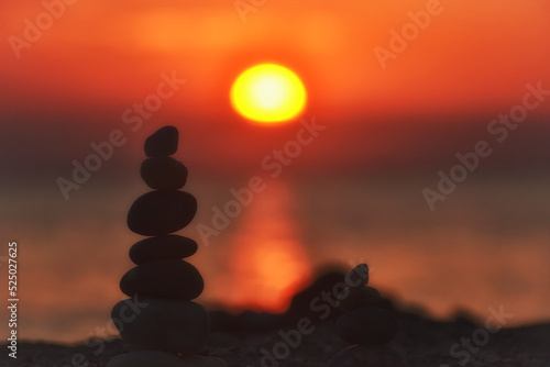 Silhouette of balanced stone pyramid on sand. Zen rock  concept of balance and harmony  stone pyramid on beach