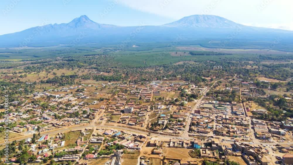 A drone flying over the rusted rooftop in the poor settlement houses in Africa. Aerial view of rooftop through a small town, in rural Africa - top down, drone shot. Mount Kilimanjaro Kenya Africa A drone flying over the rusted rooftop in the poor settlement houses in Africa. Aerial view of rooftop through a small town, in rural Africa - top down, drone shot. Mount Kilimanjaro Kenya Africa