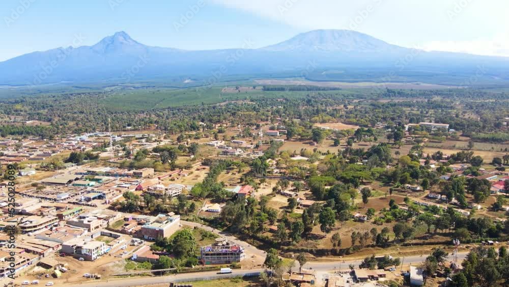 A drone flying over the rusted rooftop in the poor settlement houses in Africa. Aerial view of rooftop through a small town, in rural Africa - top down, drone shot. Mount Kilimanjaro Kenya Africa. A drone flying over the rusted rooftop in the poor settlement houses in Africa. Aerial view of rooftop through a small town, in rural Africa - top down, drone shot. Mount Kilimanjaro Kenya Africa.