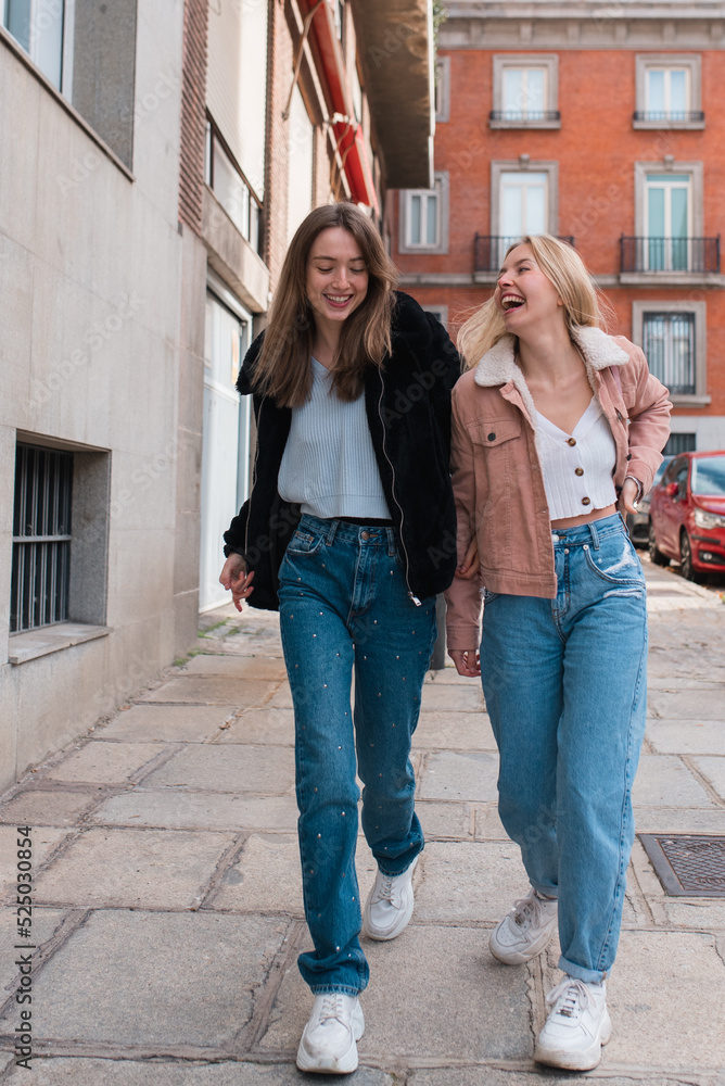 Optimistic women walking in city along street Optimistic women walking in city along street