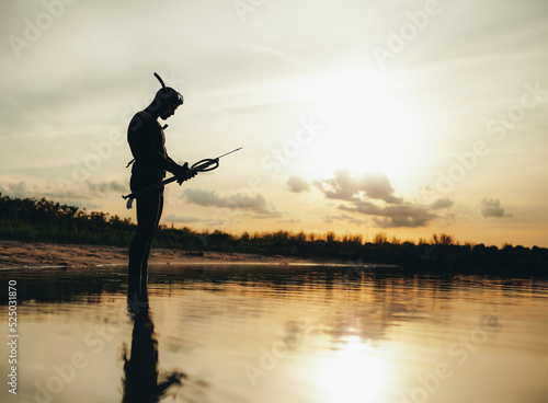 Spear fisherman checking his speargun by the sea photo
