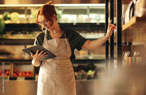 Canvastavla Supermarket owner using a digital tablet in her shop