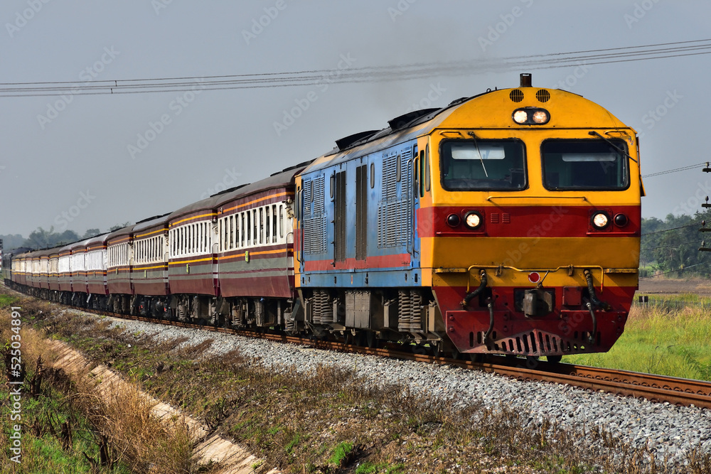 Passenger train by diesel locomotive on the railway in Thailand