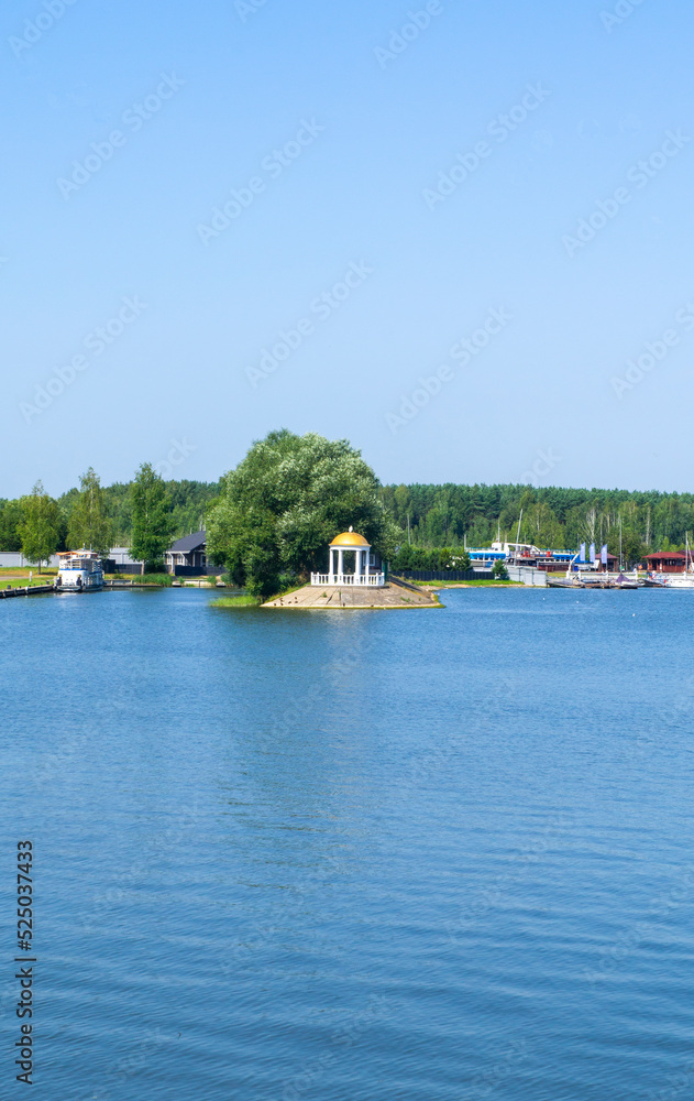 Lake view of the gazebo near the shore trees with a golden roof