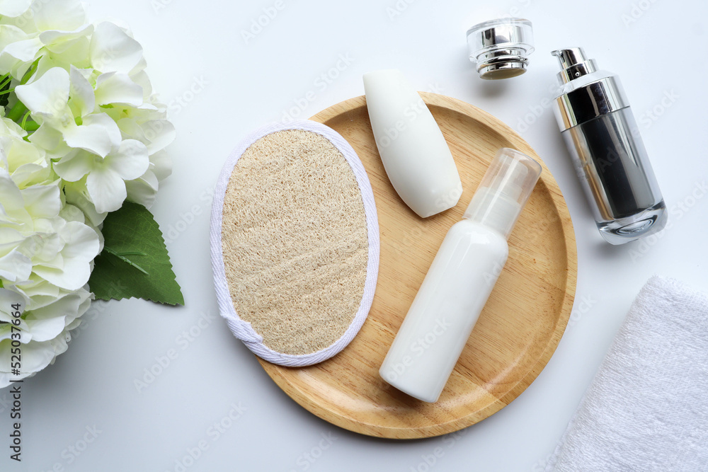 Flat lay of body care product, contain of loofah, soap and body lotion, towel and serum on white background Flat lay of body care product, contain of loofah, soap and body lotion, towel and serum on white background