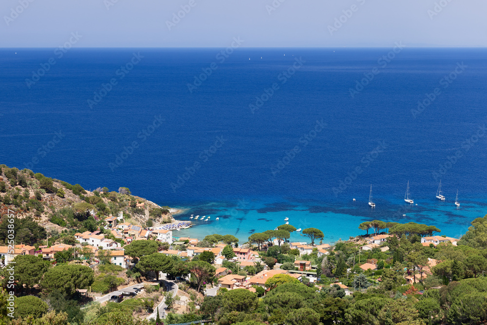 Small coastal village with a small beach, a marina and the endless turquoise expanses of Tyrrhenian Sea, Province of Livorno, Island of Elba, Italy