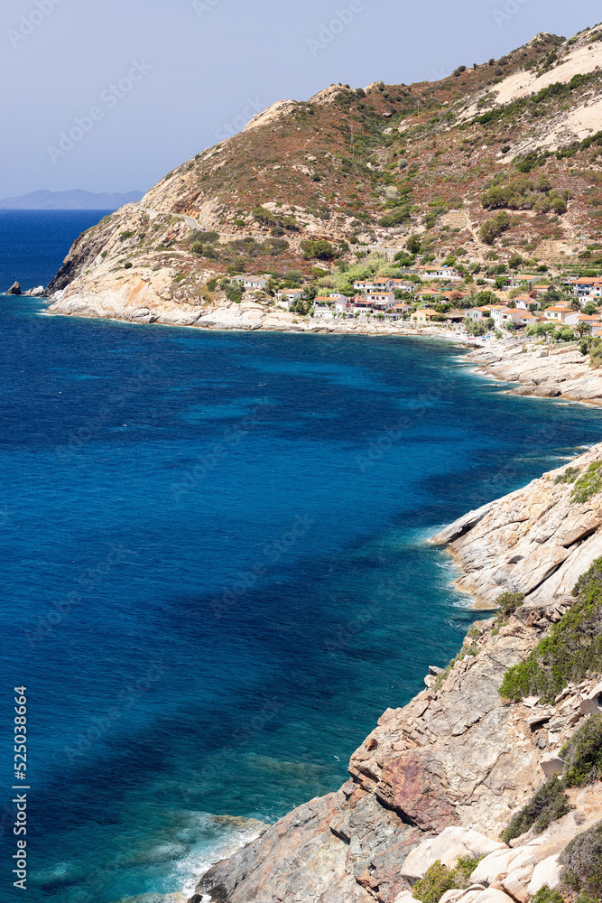 Vertical shot of Two dominant colors on the island of Elba: the yellow color of the karst rocks and the sky-blue color of the water in the local small bays, Province of Livorno, Italy