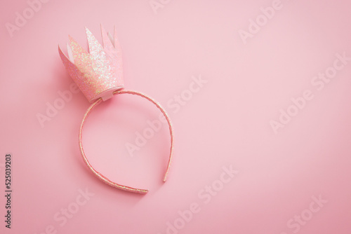 Pink princess crown headband for girls on pink background. Festive girlie feminine birthday party or performance. Flat lay minimalistic with copy space