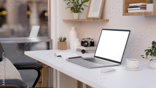 Notebook laptop mockup is on a modern white office desk with decor accessories. close-up © bongkarn