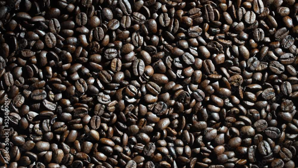Background of fresh roasted coffee beans, close up, top view, rotating. Dark coffee beans texture Background of fresh roasted coffee beans, close up, top view, rotating. Dark coffee beans texture