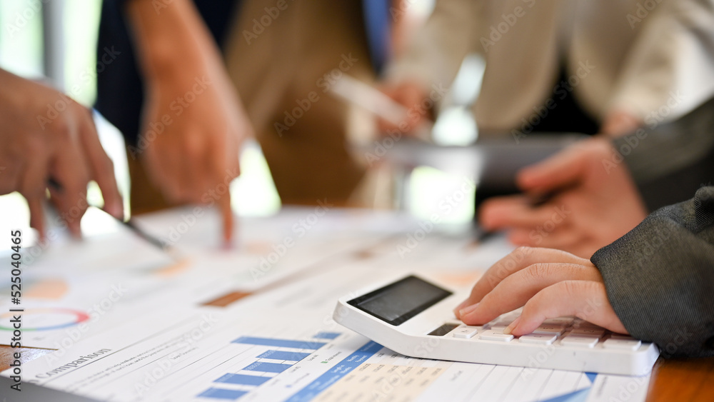A female accountant using a calculator during the meeting with her team. cropped image A female accountant using a calculator during the meeting with her team. cropped image