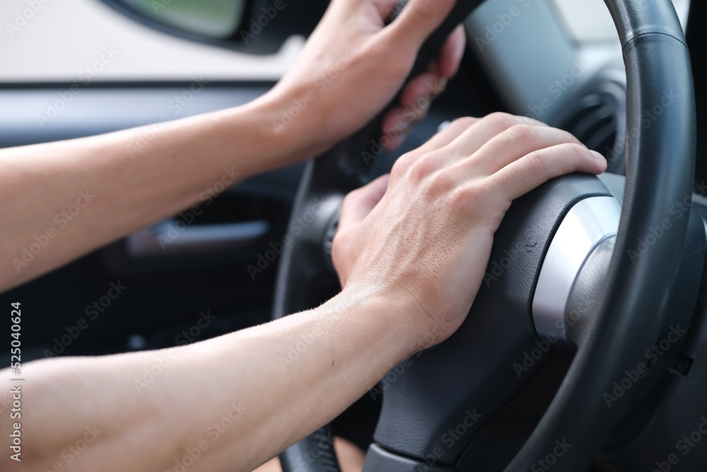 closeup of hand of driver pressing car horn button in car