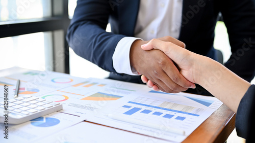 Asian female executive manager shakes hands with an African partner. Diverse businesspeople