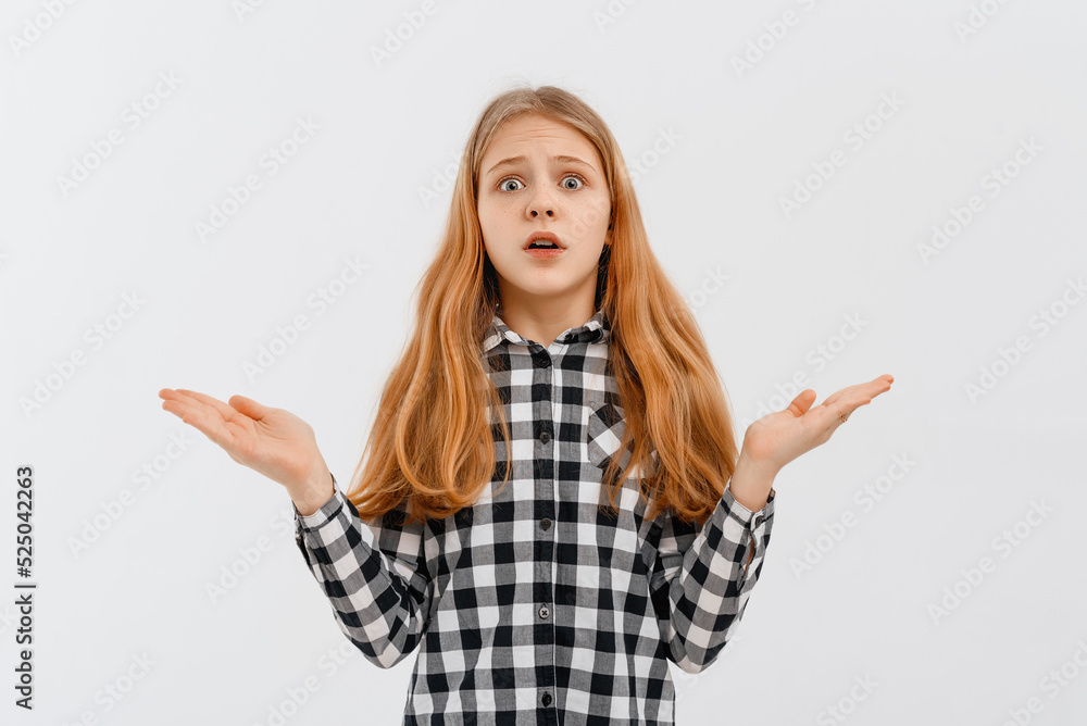 Clueless teen girl shrugs shoulders, smiles nervously, saying sorry, dont know, have nothing, standing confused against white background Clueless teen girl shrugs shoulders, smiles nervously, saying sorry, dont know, have nothing, standing confused against white background