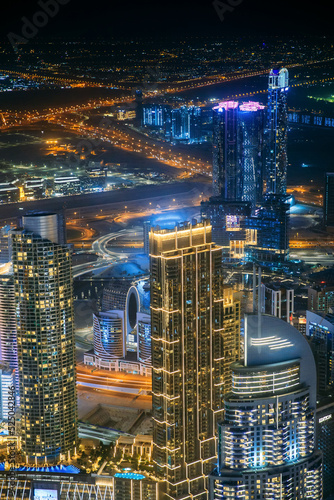 Aerial view of beautiful evening night illuminations scenic view of skyscraper and towers in Dubai. Street night traffic in Dudai skyline. Urban background of Dubai, UAE, United Arab Emirates