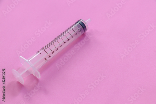 Syringe on a pink background, medical concept..