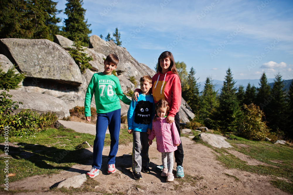 Mother with four kids resting in mountains. Family travel and hiking with childrens.