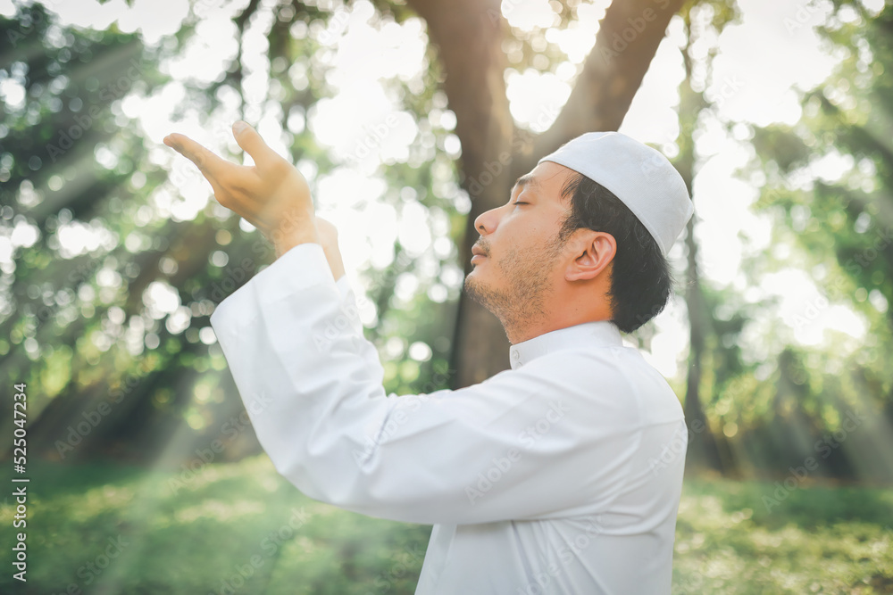 Religious muslim man traditional kandura praying outdoor at quiet nature environment sun beams. Religious muslim man traditional kandura praying outdoor at quiet nature environment sun beams.