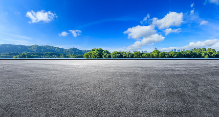 Asphalt road platform and green forest with city skyline scenery