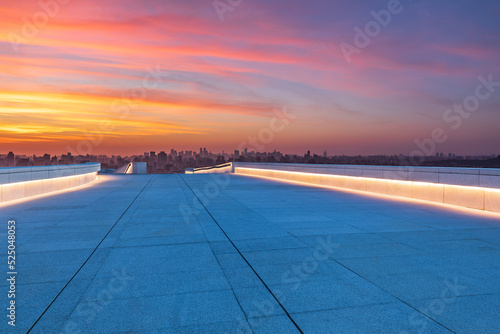 Empty floor and modern city skyline with sky clouds at sunset