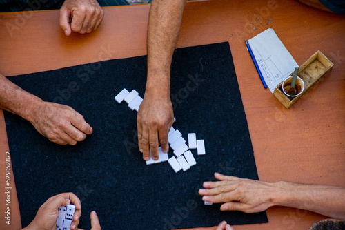 Top view of a group of people playing dominoes.