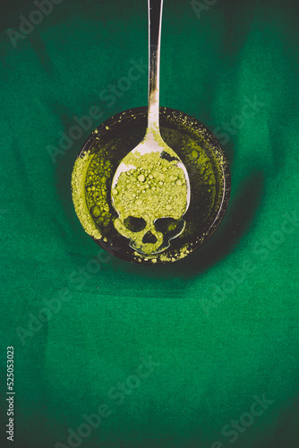 Halloween theme concept image with a skull shape spoon with green dust on it photo