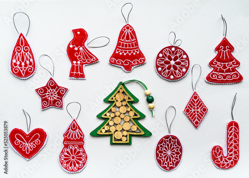 New Year and Christmas hand made red and green decorations made of wood and felt fabric on white paper. Flat lay, retro style