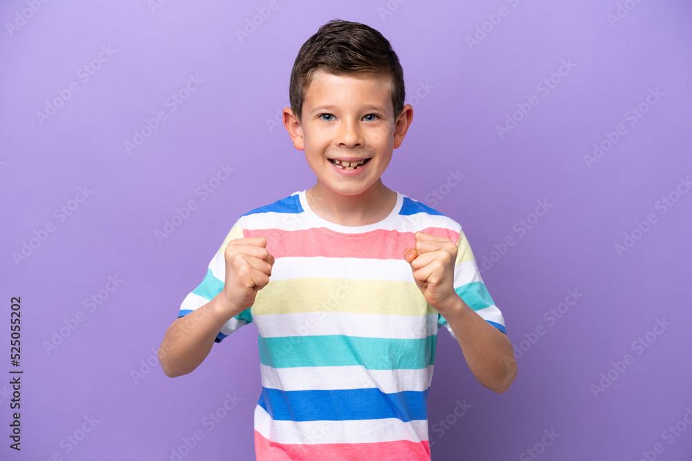 Little boy isolated on purple background celebrating a victory in winner position Little boy isolated on purple background celebrating a victory in winner position