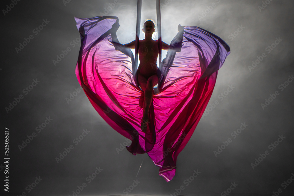 Φωτογραφία Silhouette of a young woman balancing on an airy silk ribbon and waving a cloth like butterfly wings