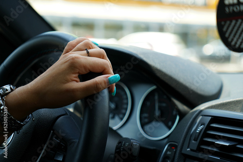 detail. detail of a woman's hand driving a car. hand on the wheel.