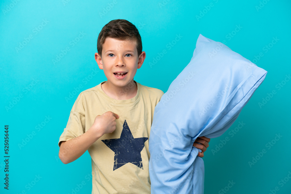 Little boy in pajamas isolated on blue background with surprise facial expression Little boy in pajamas isolated on blue background with surprise facial expression
