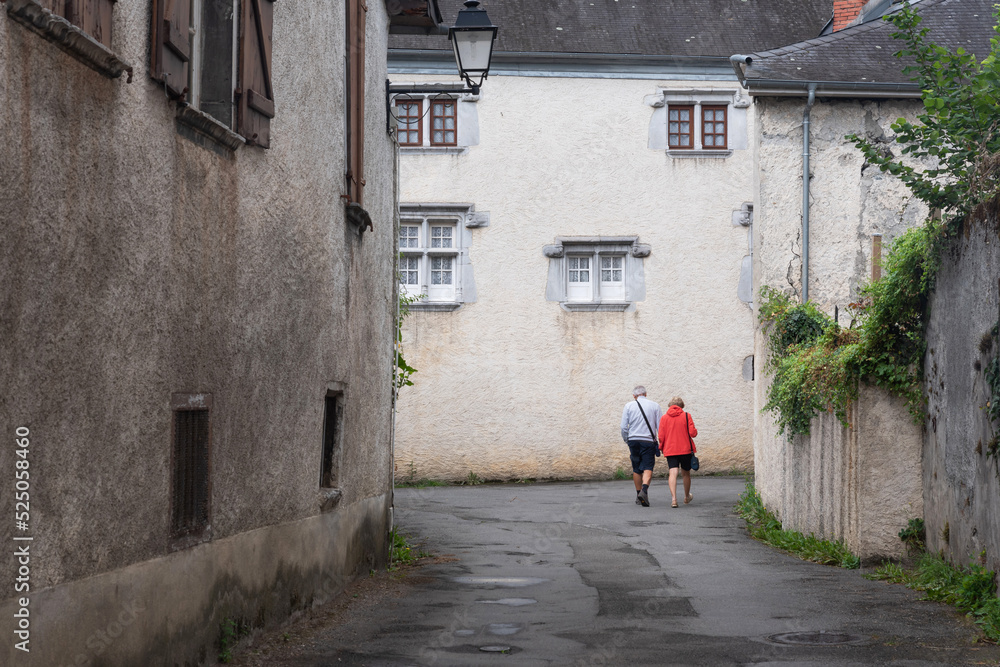 Couple walking hand in hand through the streets of Bielle. Atlantic Pyrenees