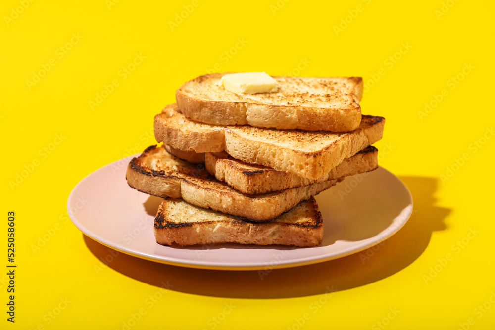 Plate of toasts with butter on yellow background Plate of toasts with butter on yellow background
