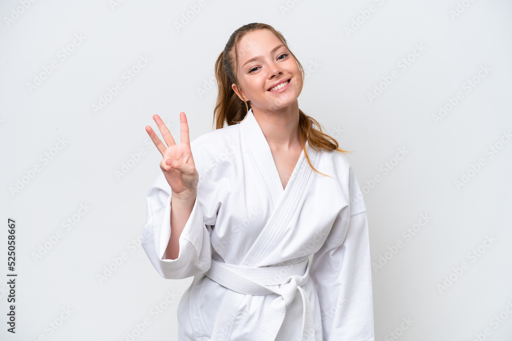 Young caucasian girl doing karate isolated on white background happy and counting three with fingers Young caucasian girl doing karate isolated on white background happy and counting three with fingers