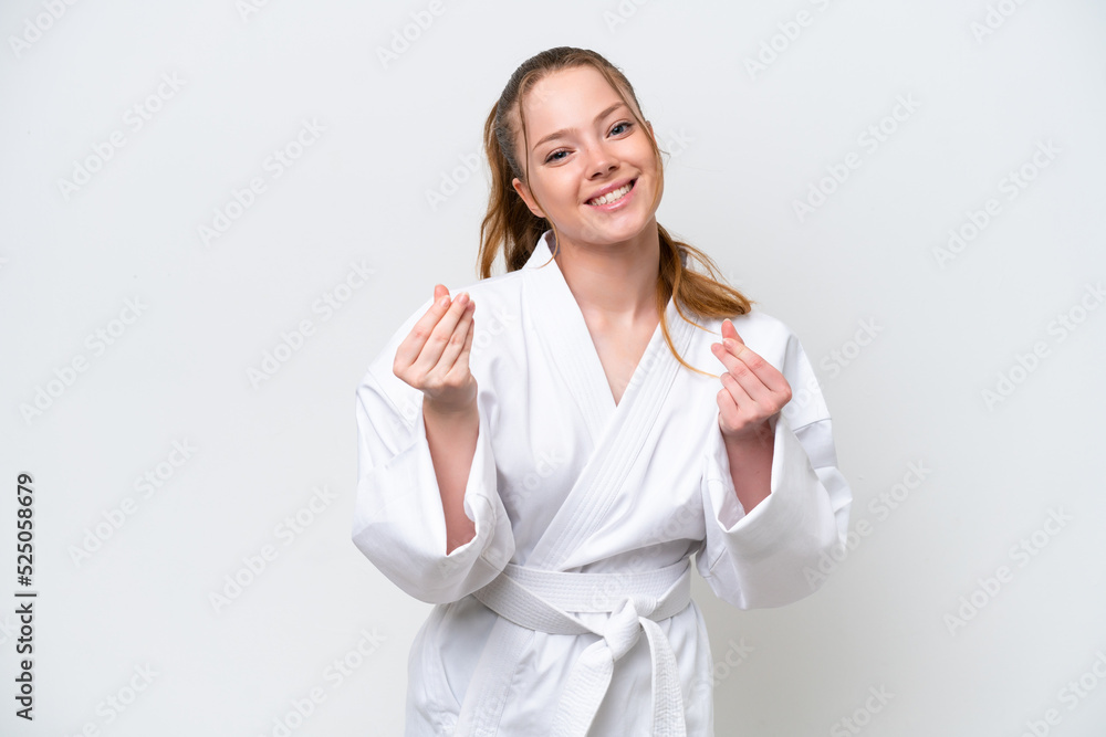 Young caucasian girl doing karate isolated on white background making money gesture Young caucasian girl doing karate isolated on white background making money gesture