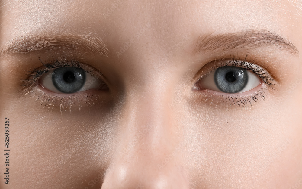 Naklejka premium Young woman with blue eyes, closeup