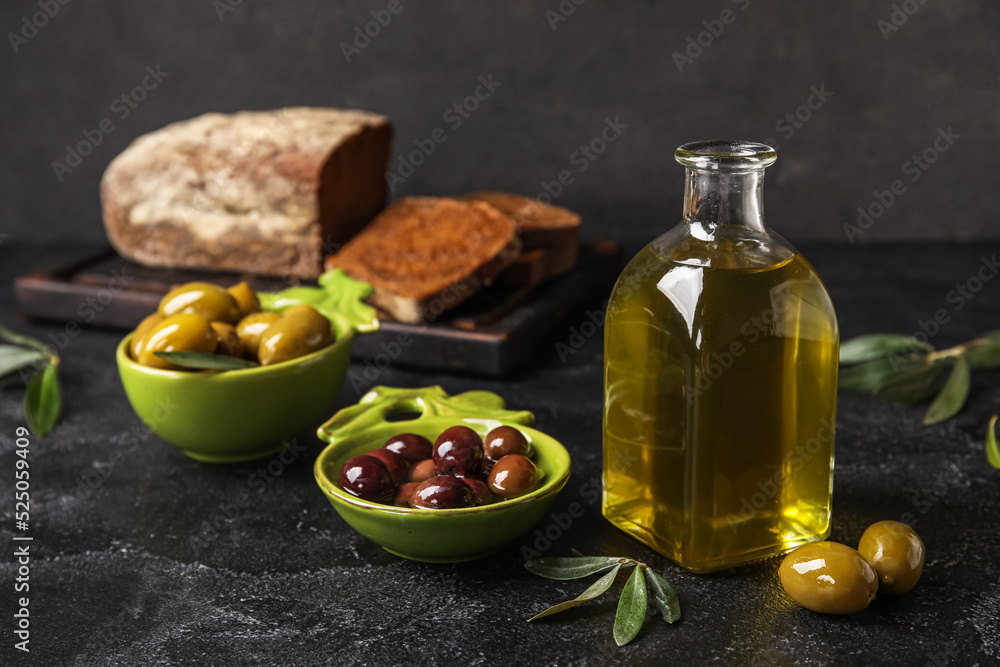 Bottle of fresh oil and olives on dark background Bottle of fresh oil and olives on dark background