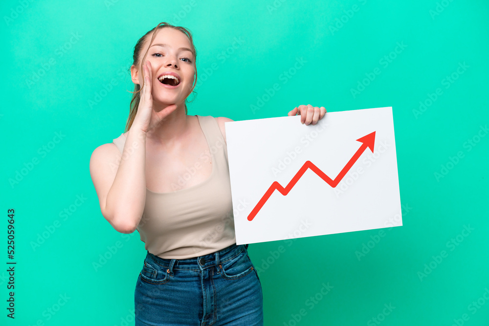 Young caucasian woman isolated on green background holding a sign with a growing statistics arrow symbol and shouting Young caucasian woman isolated on green background holding a sign with a growing statistics arrow symbol and shouting