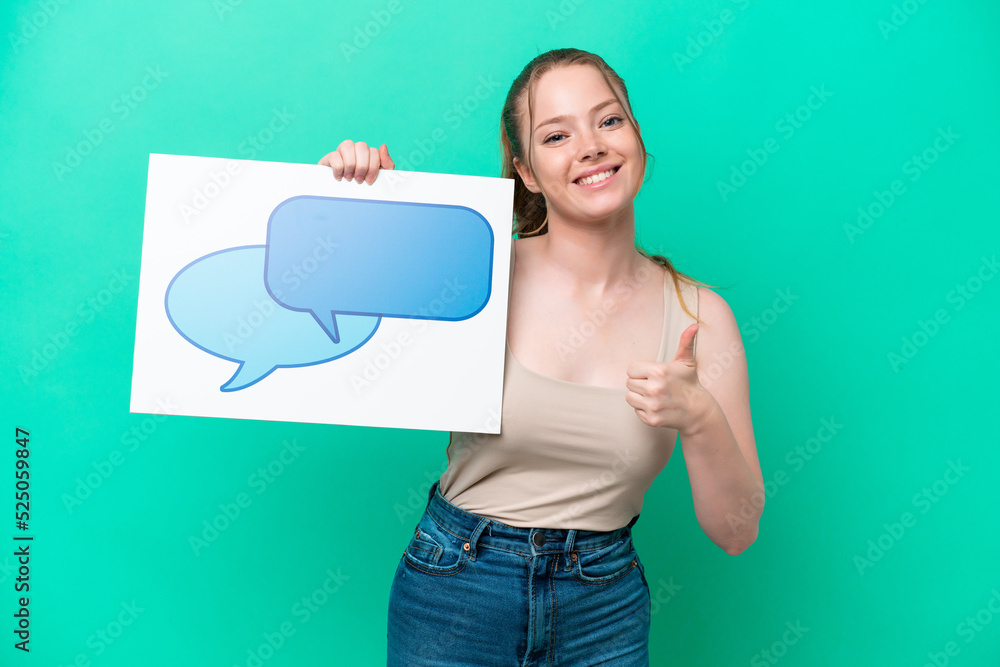 Young caucasian woman isolated on green background holding a placard with speech bubble icon with thumb up Young caucasian woman isolated on green background holding a placard with speech bubble icon with thumb up