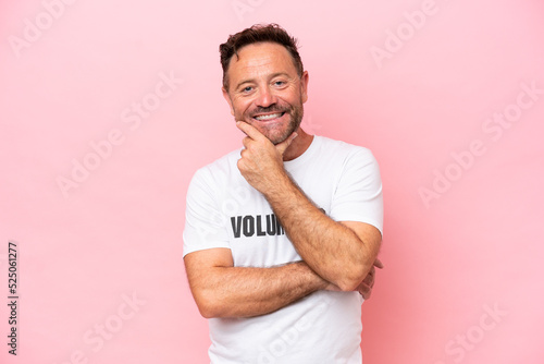 Middle age volunteer man isolated on pink background isolated on pink background happy and smiling