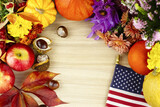 Wooden background with flowers, orange pumpkins, red leaves, chestnuts 