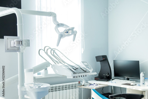 View dental equipment in dentist office in new modern stomatological clinic room. Background of dental chair and accessories used by dentists in blue  medic light. Copy space  text place