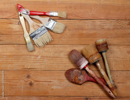 Several old and new brushes on a rustic background.