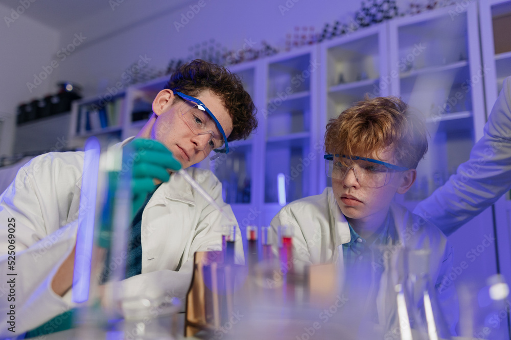 Science students doing chemical experiment in the laboratory at university. Science students doing chemical experiment in the laboratory at university.