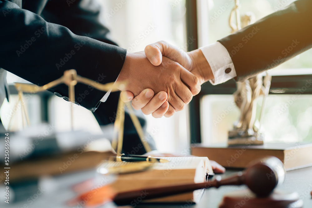 Businessman shaking hands to seal a deal with his partner lawyers or attorneys discussing a contract agreement.Legal law, advice, and justice concept - obrazy, fototapety, plakaty 