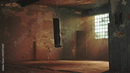 Punching bag swinging on a chain in an old building